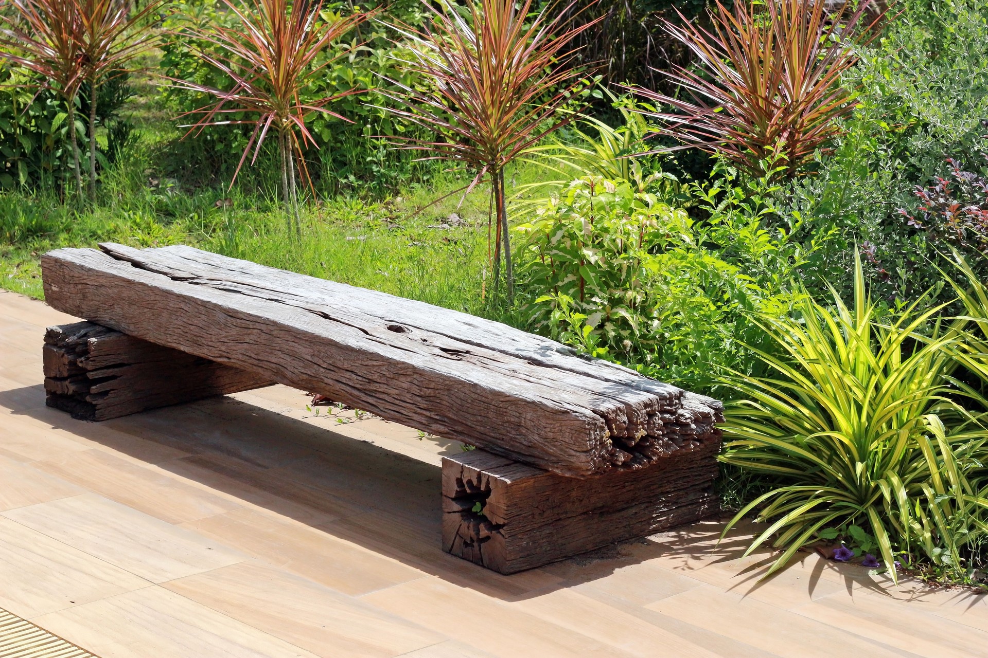 Rustic wood bench at the edge of a garden in summer